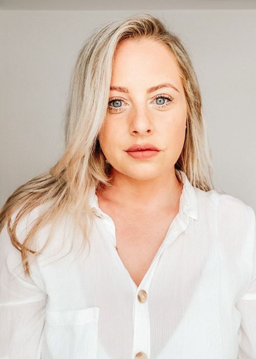 Photo of blonde-haired woman looking at the camera, smiling professionally.