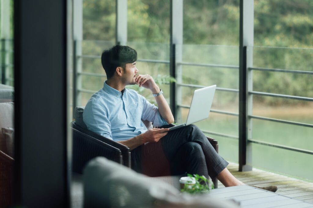 Man sat by window with laptop