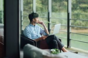 Man sat by window with laptop