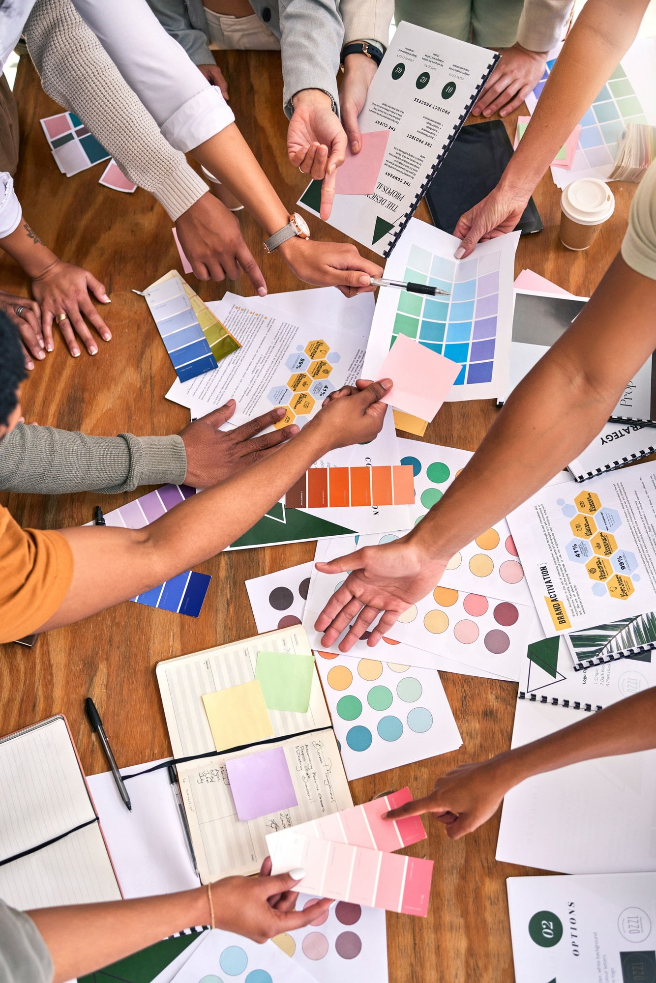 Multiple team members talking over a branding project with paperwork on table