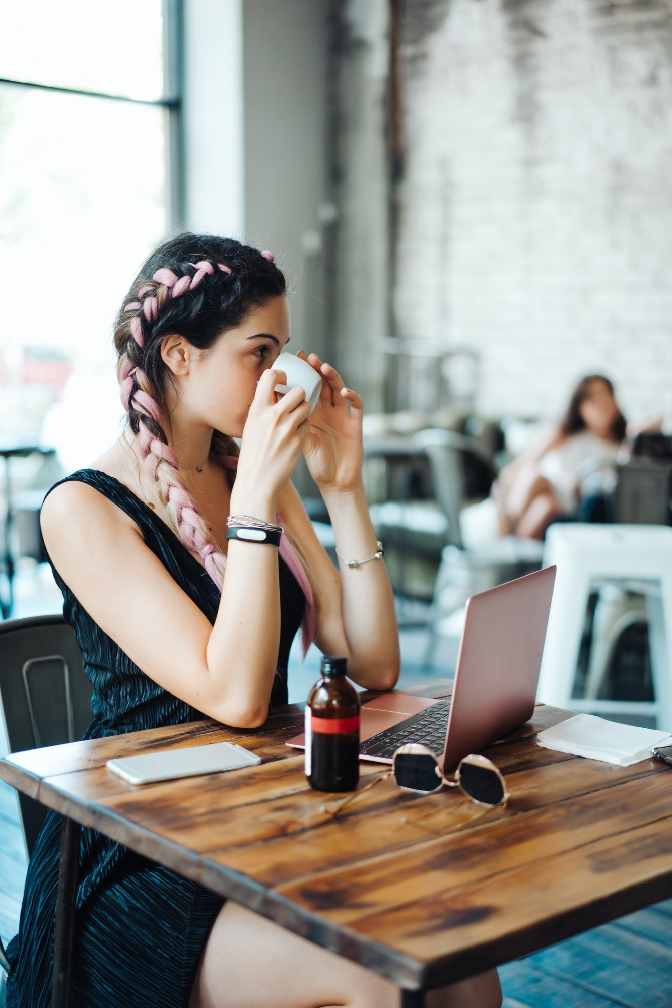 Young woman sitting in coffee shop with laptop